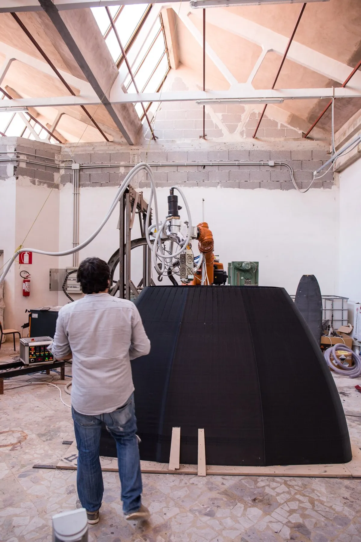 Francesco Belvisi next to the bow of a 3D-printed boat in the NUGAE laboratory