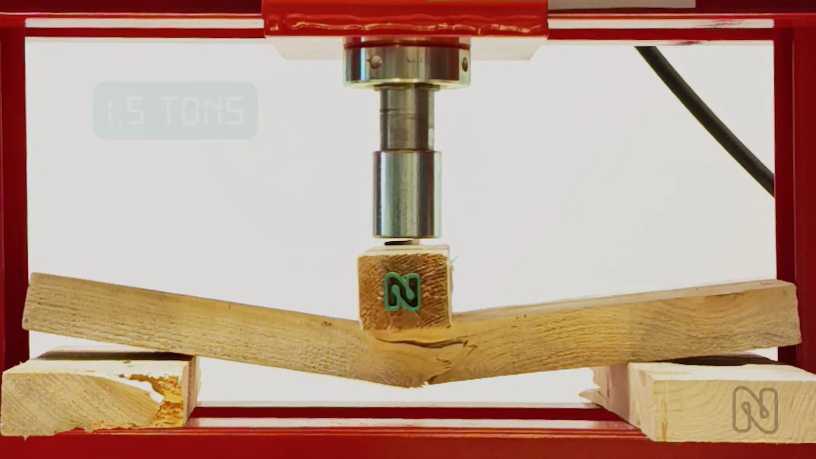 The solid wood beam snaps under the press at 1.5 tonnes