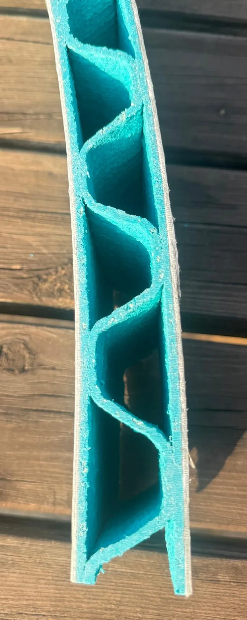 Cross-section of the laminated element: the triangular cells of the CoreLight3D® printed core between the fibreglass skins
