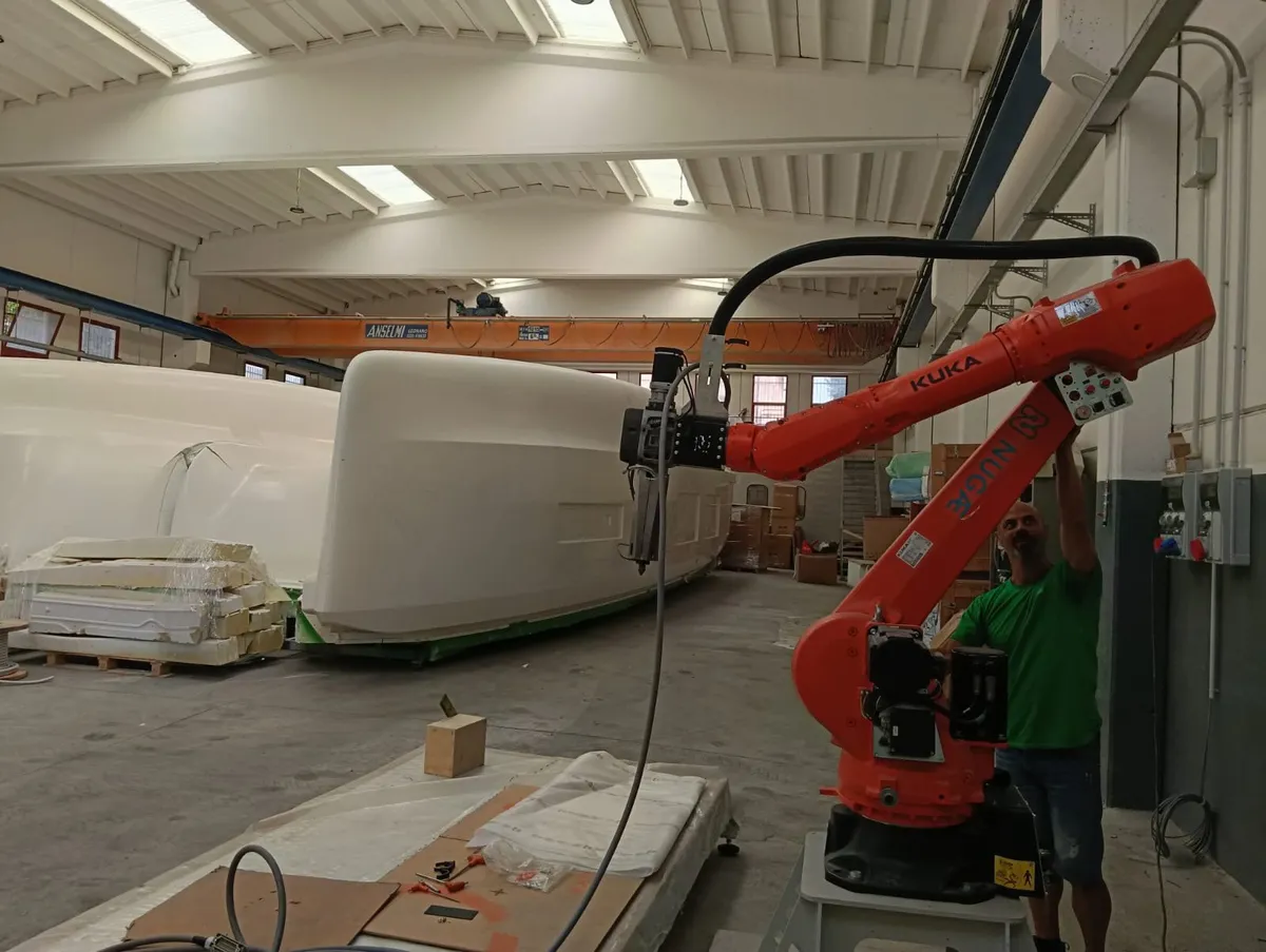 The NUGAE robot installed at a shipyard next to a large hull
