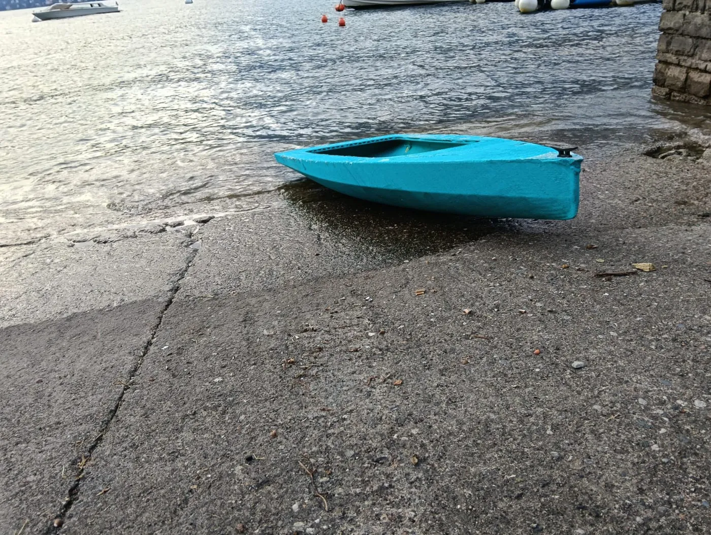 The 3D printed Printarella1 hull, turquoise, on the shore of Lake Como