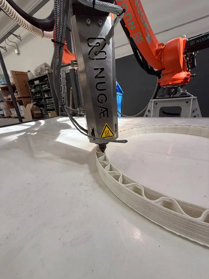 NUGAE extruder printing a ring with wave-shaped ribs in a shipyard